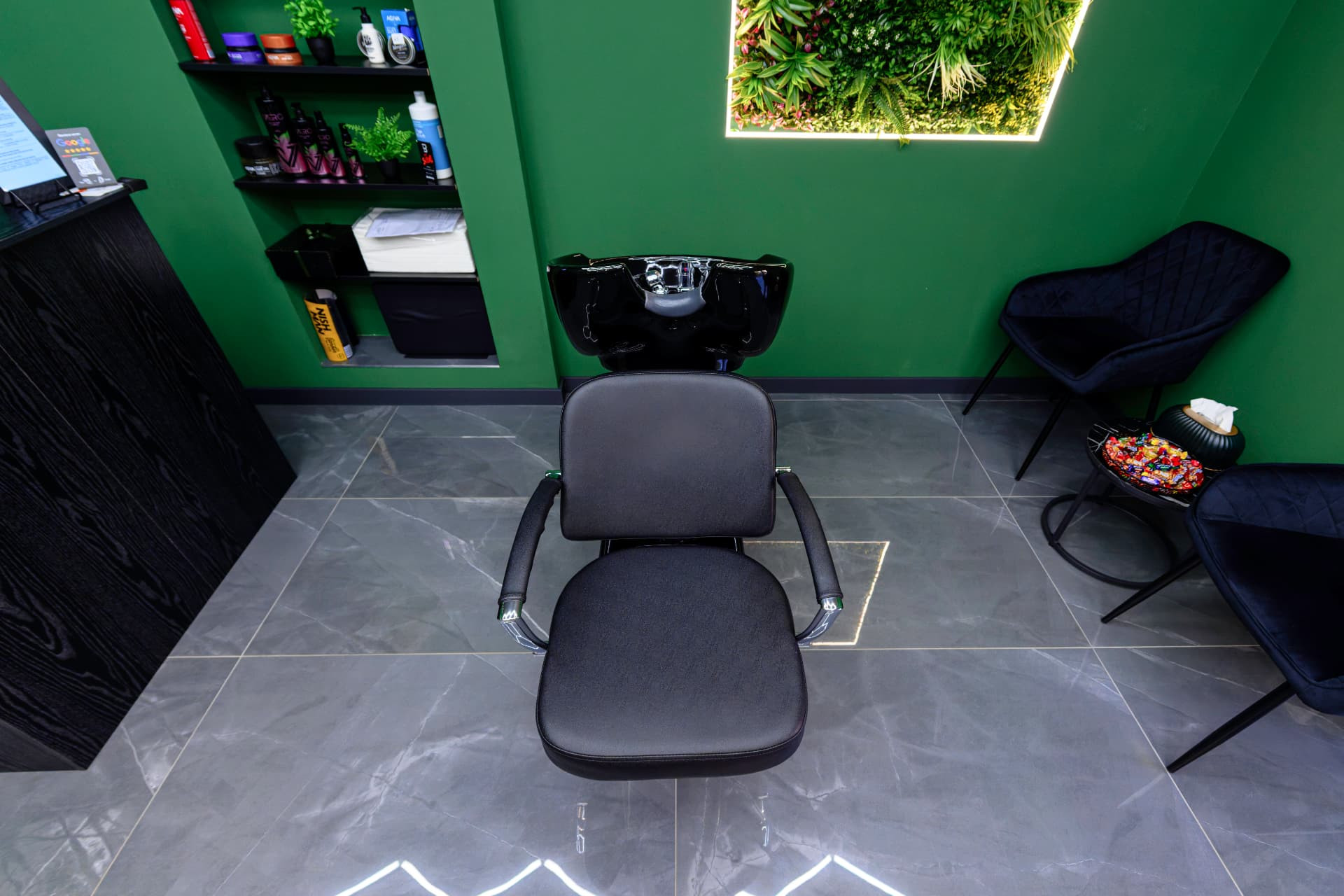 Scaun de spălare negru și raft cu produse de styling în Joker Fade Barbershop