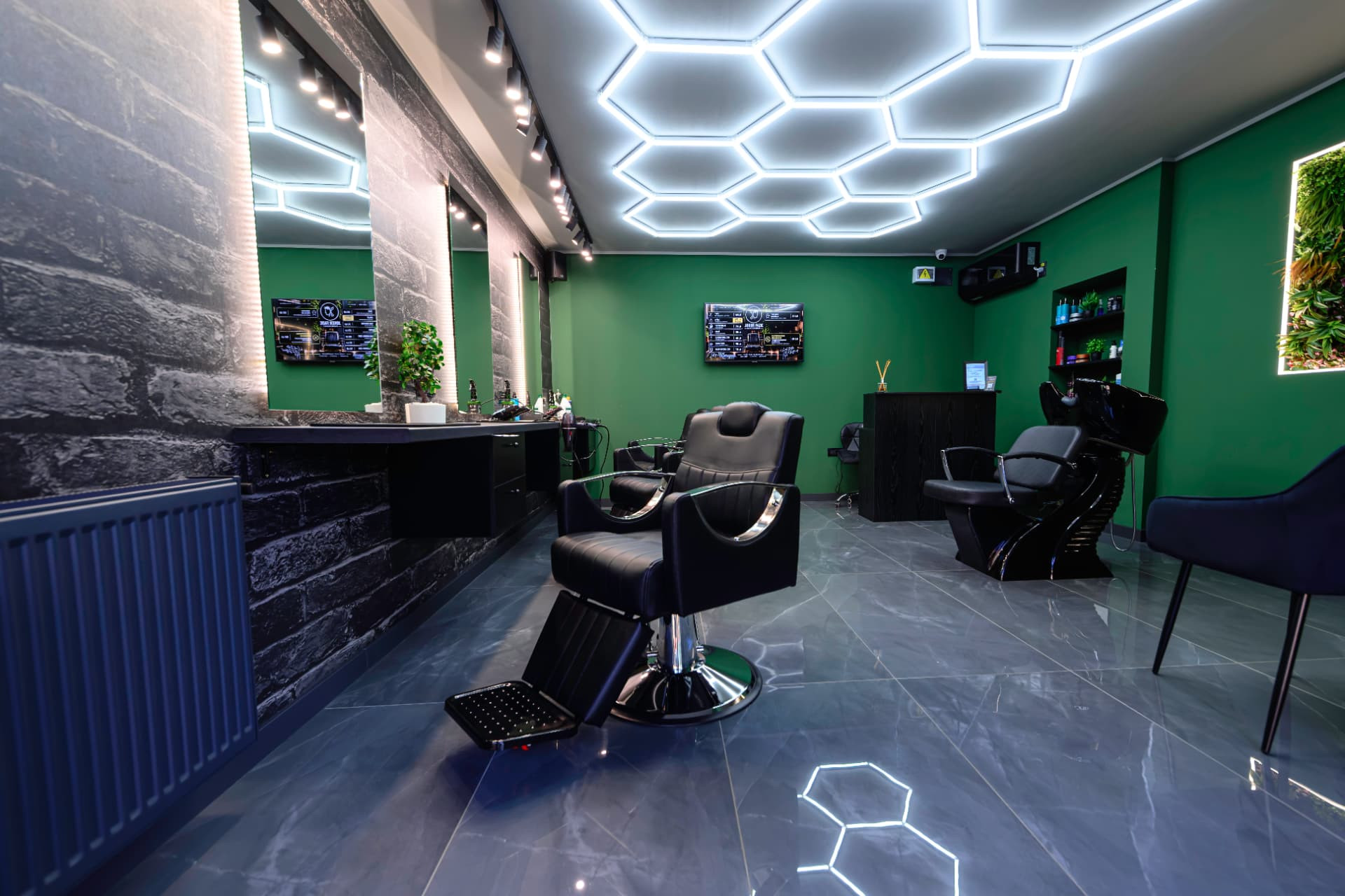 Scaun de barberie sub lumini hexagonale LED în Joker Fade Barbershop